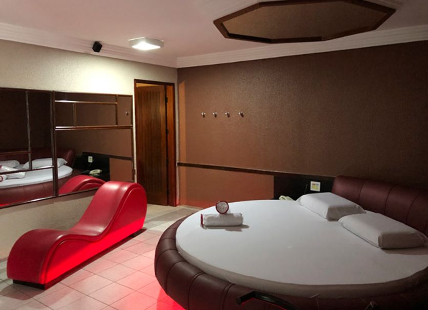 Ambiente interno real do Dreams Motel com cama redonda e poltrona